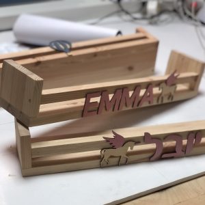 מדף ספרים מעץ עם שם וחד קרן