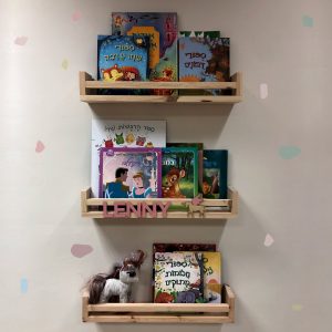 מדף ספרים מעץ עם שם וחד קרן